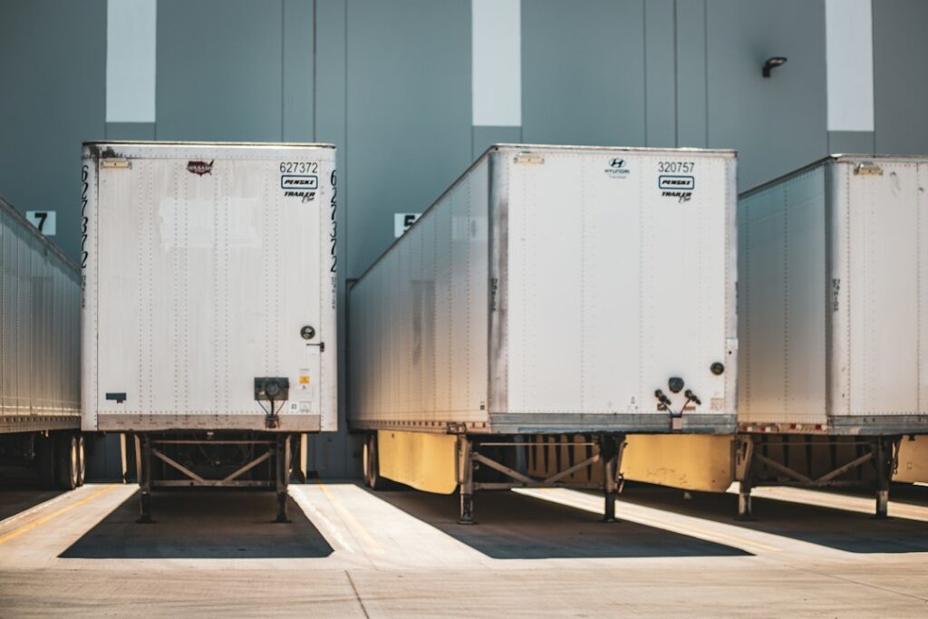 Fleet of American semi trucks at a freight facility