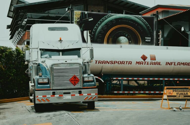 Semi truck parked beside heavy industrial equipment